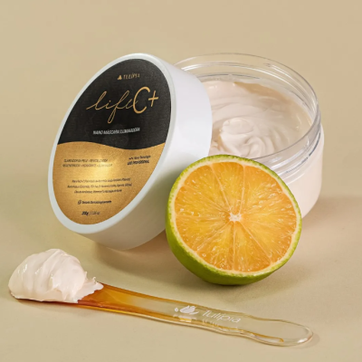 Creme facial Life C+ com tampa preta e dourada, laranja cortada e espátula com creme