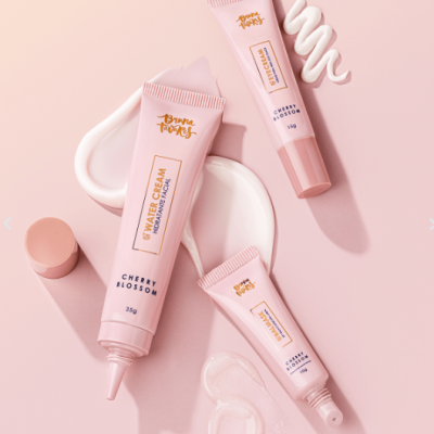 Tubo de creme cor-de-rosa e amostras do produto em fundo rosa