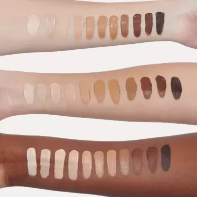 Amostras de maquilhagem em creme em três braços com diferentes tons de pele