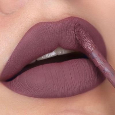 Lábios com batom líquido mate rosa antigo sendo aplicado