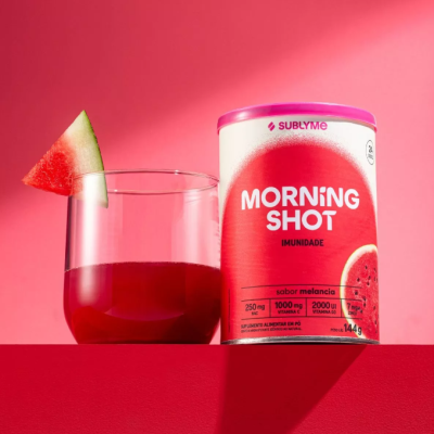 Embalagem de suplemento Morning Shot sabor melancia ao lado de copo com bebida vermelha e fatia de melancia
