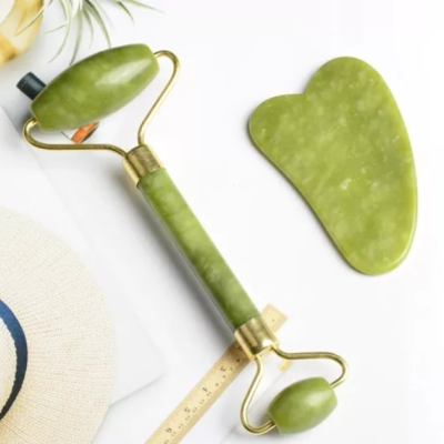 Massajador facial de pedra verde com rolo e placa sobre superfície branca