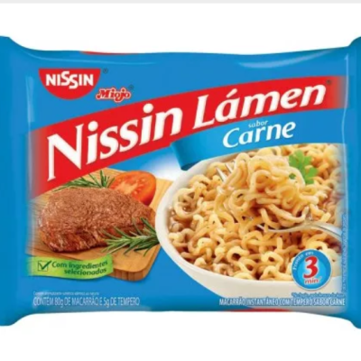 Pacote azul de Nissin Lámen sabor Carne com imagem de bifes, tomate e lámen pronto.