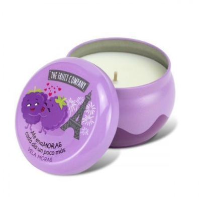 Vela perfumada em lata roxa com tampa ilustrada e texto em castelhano.