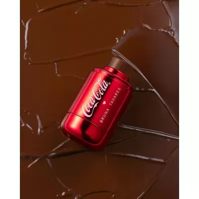 Frasco de perfume vermelho brilhante Coca-Cola sobre chocolate derretido
