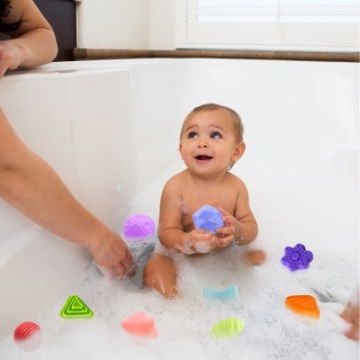 Bebé numa banheira com brinquedos coloridos de silicone