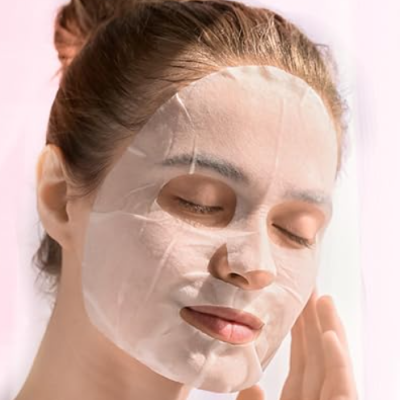 Mulher com máscara facial de tecido branco em fundo claro