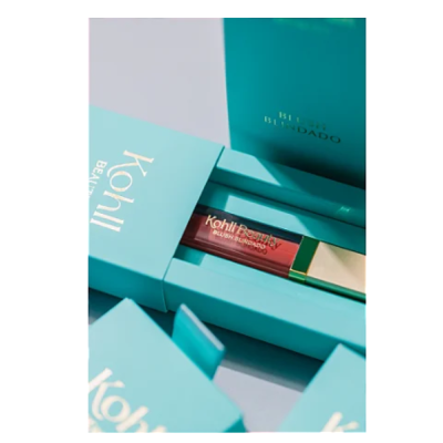 batom castanho em embalagem azul-turquesa com texto dourado Kohll Beauty e Batom Blindado
