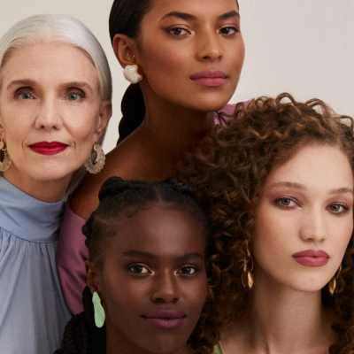 Quatro mulheres com brincos coloridos e roupa casual em fundo claro