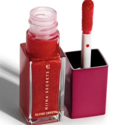 Frasco aberto de gloss labial vermelho brilhante com aplicador esponjoso