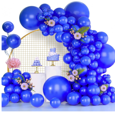 Decoração com balões azuis e bolo azul com estrelas brancas em mesas brancas