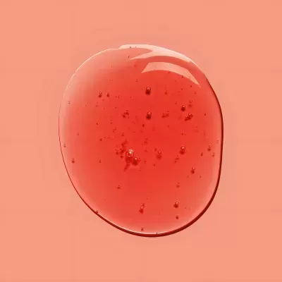 Gota de líquido vermelho translúcido com bolhas em fundo laranja