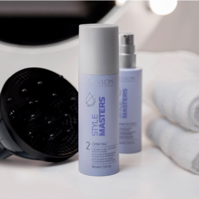 Frascos de cosmético Revlon Professional Style Masters com difusor de cabelo e toalhas brancas