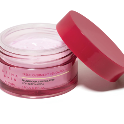 Frasco de creme rosa com tampa rosa aberto mostrando creme interno