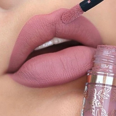 Aplicação de batom líquido mate rosa antigo nos lábios