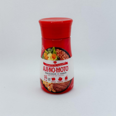 Frasco vermelho de AJI-NO-MOTO realçador de sabor numa superfície branca
