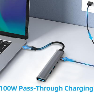 Hub USB-C cinza com vários portos e cabo azul ligado a portátil e tomada