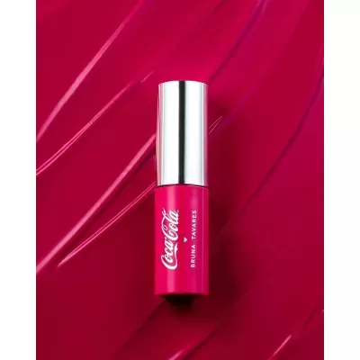 Frasco de batom rosa com tampa prateada e textos CocaCola e BRUNA TAVARES.