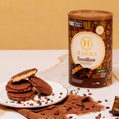 Biscoitos de chocolate com embalagem HAOMA Biscottino junto a tecido castanho e grãos de cacau