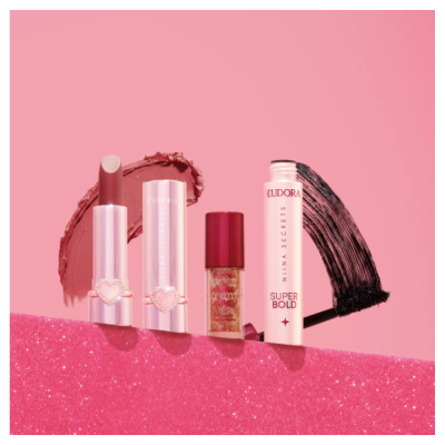 Produtos de maquilhagem Eudora sobre fundo rosa com glitter