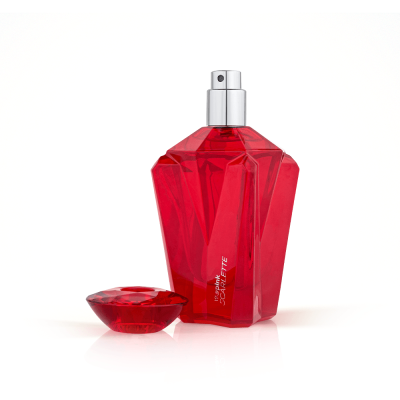 Frasco vermelho facetado de perfume com tampa arredondada ao lado