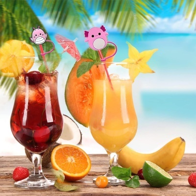 Duas bebidas tropicais em copos altos com frutas e decoração numa mesa de madeira à beira da praia
