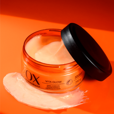 Frasco laranja com creme para cabelos Vita Glow da OX com tampa preta