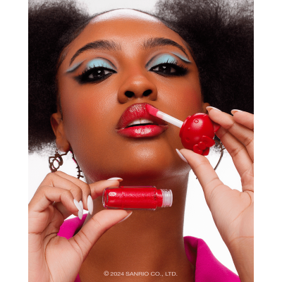 Mulher aplicando batom líquido vermelho com embalagem vermelha de personagem Hello Kitty