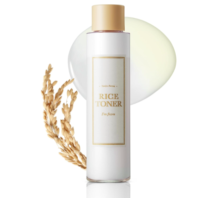 Frasco branco com tampa dourada de toner Rice com ramo de arroz seco e mancha translúcida ao fundo