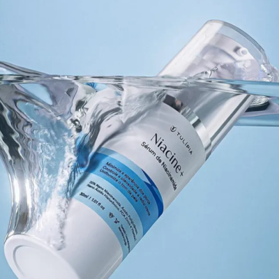 Frasco de soro hidratante Niacinex da marca TULIPA submerso em água