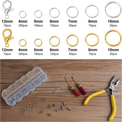 Acessórios de bijuteria em caixa transparente com brincos e alicates sobre madeira