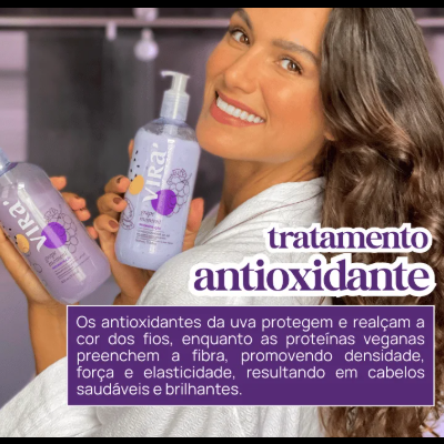 Mulher sorridente segura garrafas do produto Vira tratamento antioxidante para cabelo