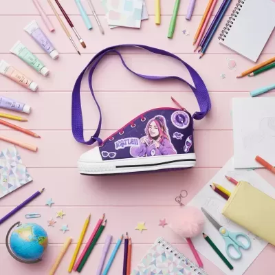 Mala em forma de sapatilha roxa com ilustração de rapariga rodeada por material escolar colorido sobre mesa rosa