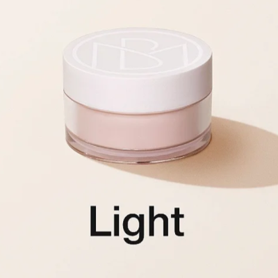 Frasco pequeno de pó compacto com tampa branca e a palavra 'Light' em fundo bege