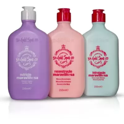 Três frascos de produtos capilares By Gold Spell co nas cores lilás, rosa e azul claro com tampas de pressão.