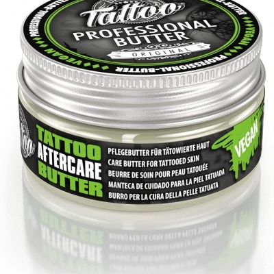 Pote metálico de manteiga de cuidado para tatuagens com rótulos preto e verde, destacando 'VEGAN'