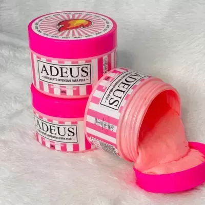 Frascos cor de rosa e branca de tratamento para pele ADEUS com creme rosa derramado