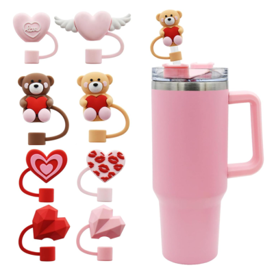 Conjunto de tampas decorativas USB para canecas com designs de corações e ursos ao lado de caneca térmica rosa
