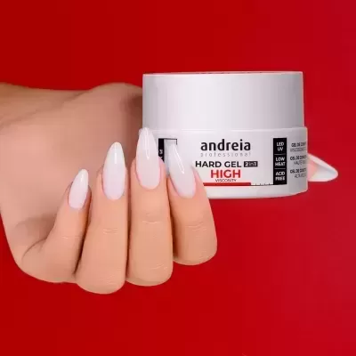 Frasco branco de gel para unhas segurado por mão feminina com unhas brancas, fundo vermelho.