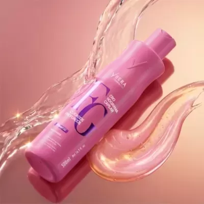 Frasco rosa de produto cosmético Ybera sobre fundo cor de rosa com líquido translúcido