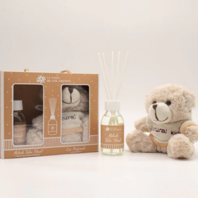Conjunto de presente com difusor de aromas, toalha e urso de peluche.