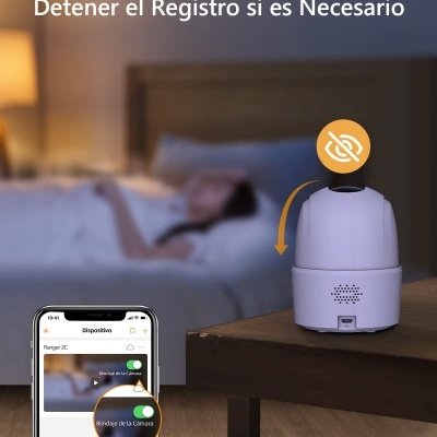 Dispositivo branco cilíndrico numa mesa ao lado de uma cama com texto em espanhol e smartphone mostrando aplicação