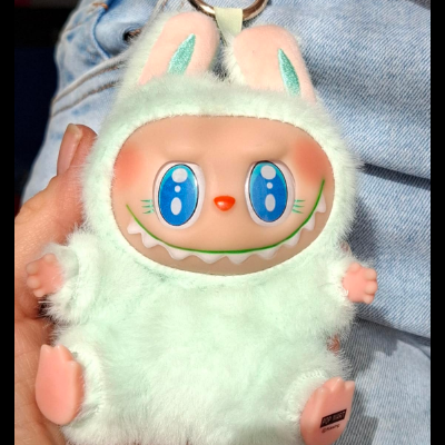 Boneco chaveiro de pelúcia verde claro com rosto plástico e orelhas de coelho