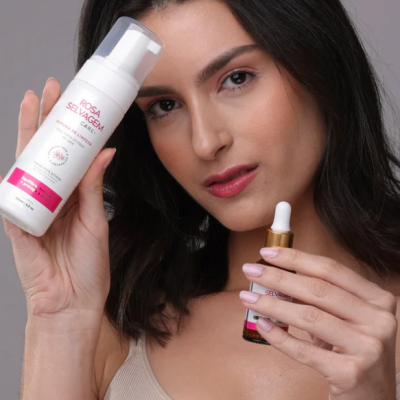 Mulher segurando produtos cosméticos Rosa Selvagem Care