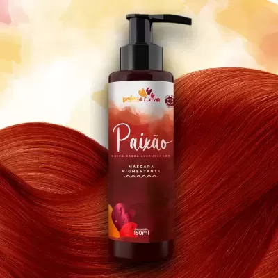 Frasco de máscara pigmentante vermelho com texto Paixão, acompanhado de mechas de cabelo ruivo.