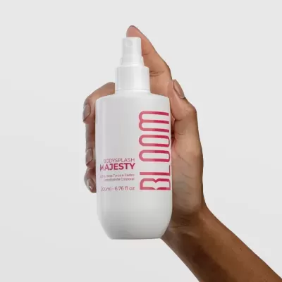 Frasco branco de spray BLOOM segurar por mão de tom médio