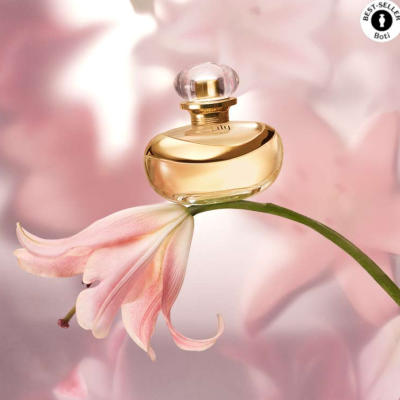 Frasco de perfume dourado numa flor rosa com selo BEST-SELLER Bolt