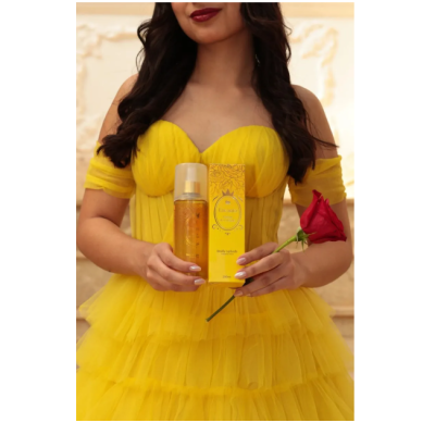 Mulher vestida de amarelo segurando body splash e rosa vermelha