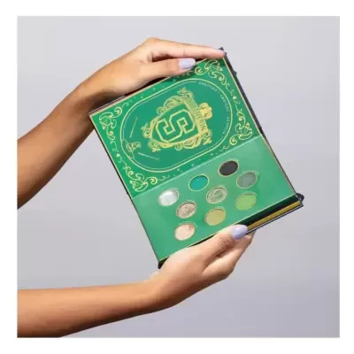 Paleta de maquilhagem Slytherin verde e dourada com 9 sombras coloridas nas mãos