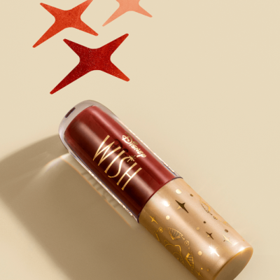 Embalagem de produto cosmético Disney Wish vermelho e dourado com estrelas no fundo bege